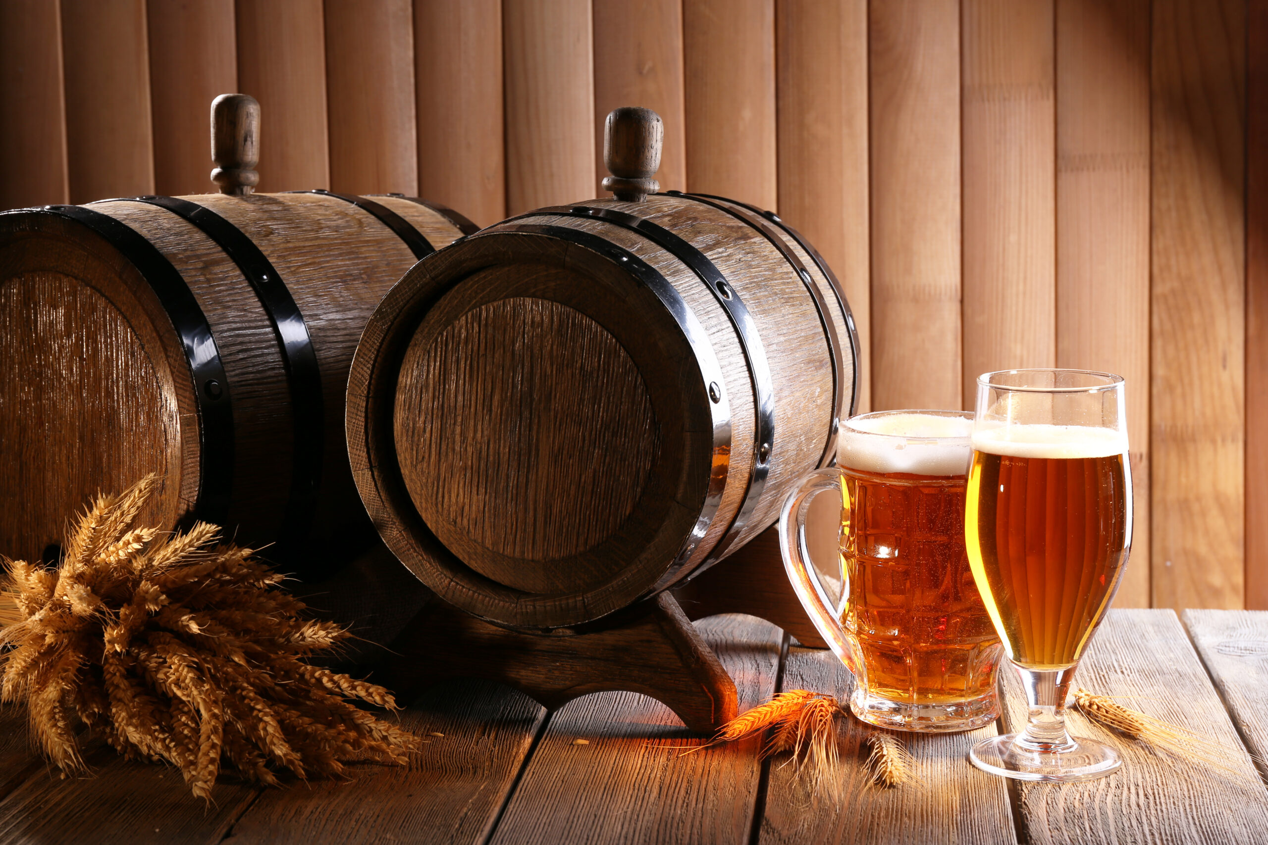 Beer barrel with beer glasses on table on wooden background